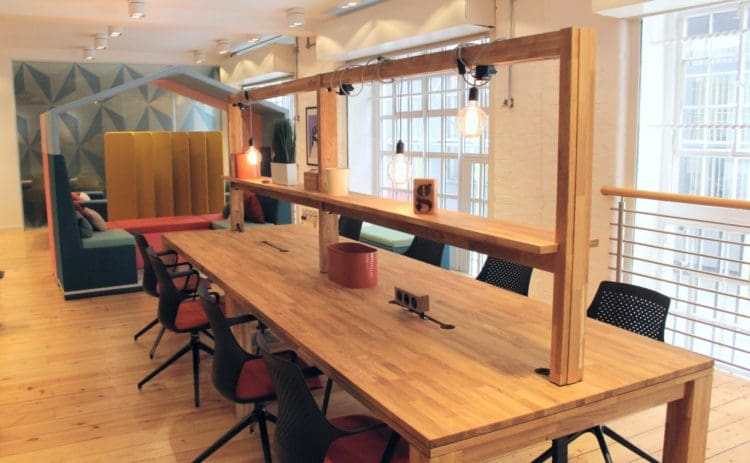 one of the collaborative office furniture solutions displayed at clerkenwell design show: an eight person desk with integrated power