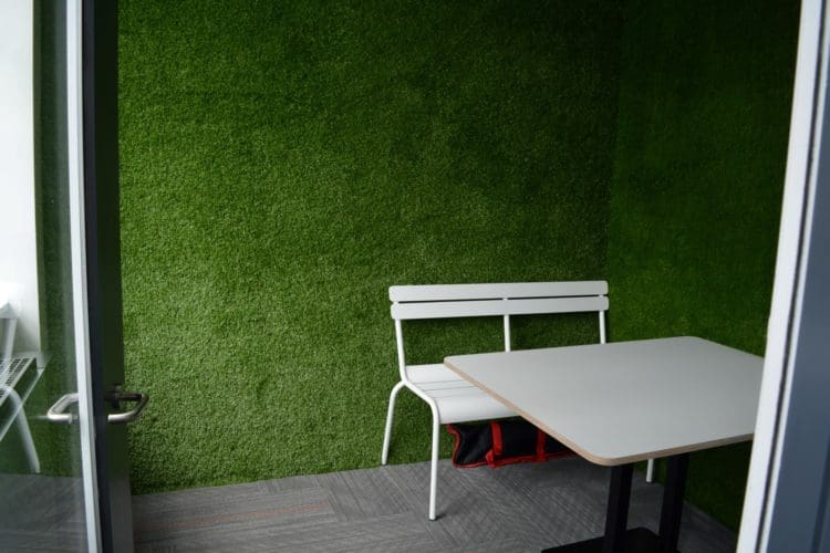 an office meeting room with artificial grass walls implemented for the hudl interior fit out
