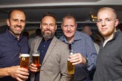 staff members of fit out company rap interiors posing with pints of lager