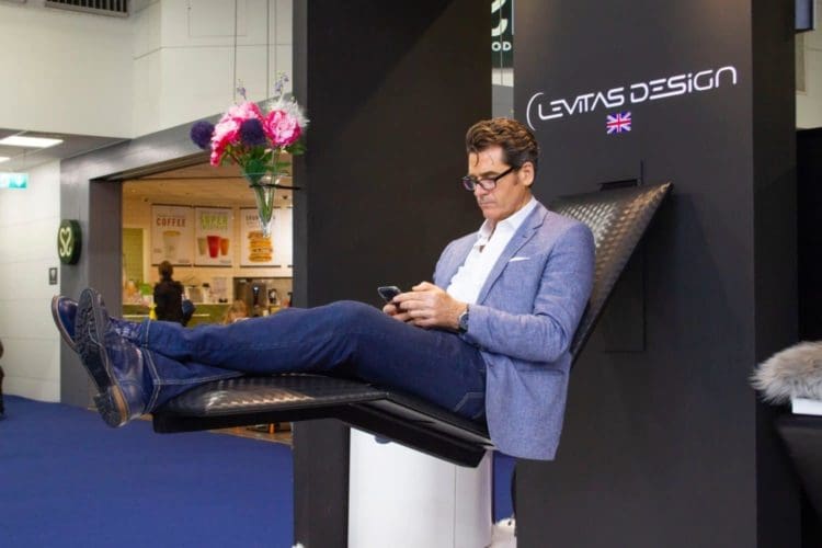 the owner of levitas design sitting on his floating chair invention at 100 percent design london