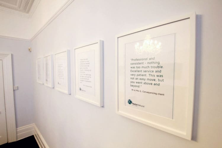 a feature wall with framed testimonials at the martin tolhurst office