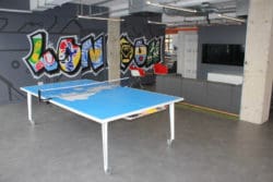 an office breakout area design with a ping pong table and soft furniture