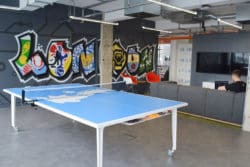 a modern london office design with a ping pong table and graffiti mural