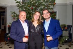 Rap Interiors director Rick Anderson with two guests at a Christmas party