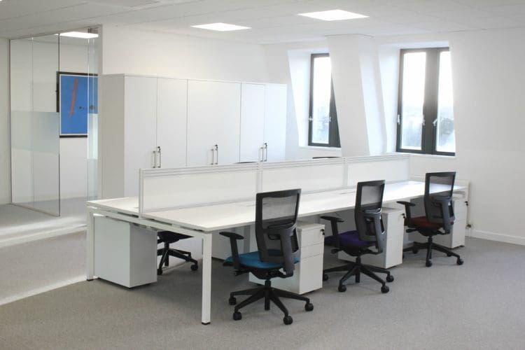 White commercial office design with comfortable chairs and a shared desk