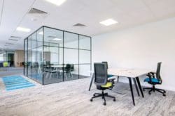 a completed commercial office refurbishment with shared desks and a crittall glass meeting room