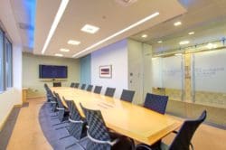 Corporate Office Boardroom Interior Design with a Large Shared Desk and Glass Doors