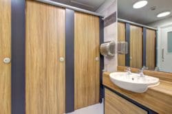 a finished school washroom refurbishment in london with wood effect cubicles