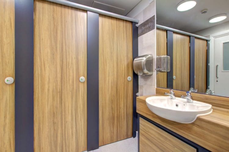 a finished school washroom refurbishment in london with wood effect cubicles