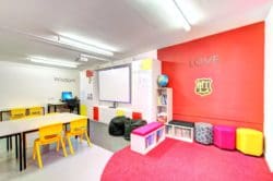 a modern school classroom design with a whiteboard and a reading area for children