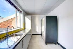a staff kitchen with cooking facilities and two vending machines