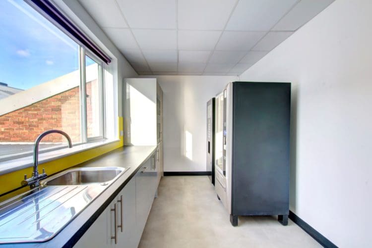 a staff kitchen with cooking facilities and two vending machines