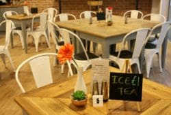 cafe interior design in kent with wooden dining tables and white metal chairs
