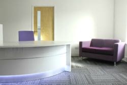 office reception area design with purple chairs and a desk