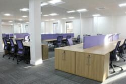 open plan office with glass partitions conceived by interior designers from london