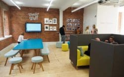 Workspace interior design with a meeting pod and imitation brick wall