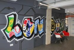 a sports themed workspace interior design with a colourful graffiti mural and furniture