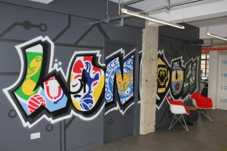 a sports themed workspace interior design with a colourful graffiti mural and furniture