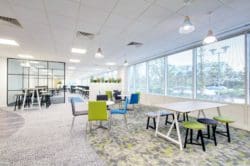 Office breakout space design with dining furniture and a colourful carpet