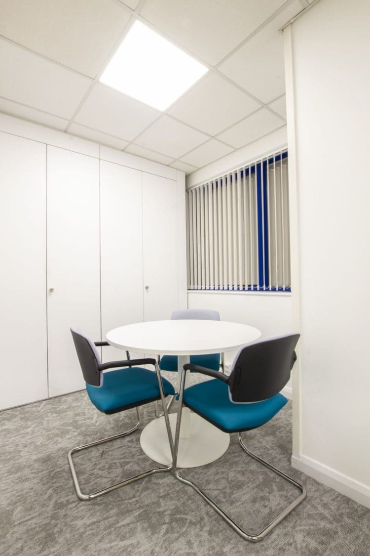 Ad-hoc executive office meeting room with a round table and chairs