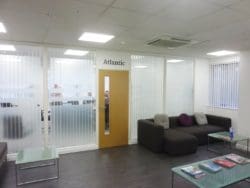 Glass office boardroom with a wooden door installed by Brighton fit out company Rap Interiors