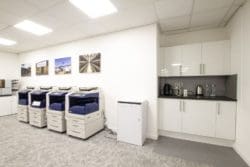 Modern office tea point with an adjoining printing area and sussex themed decorations