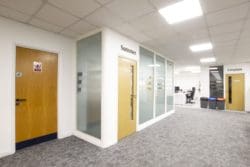 Office meeting room with frosted glass partitions and a wooden door