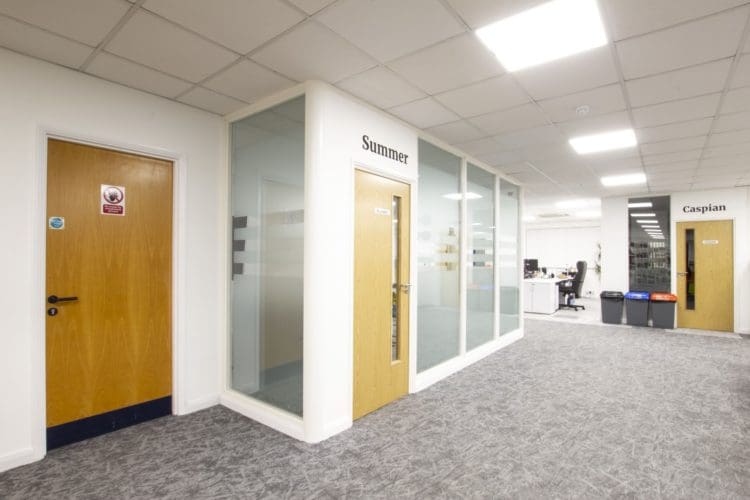 Office meeting room with frosted glass partitions and a wooden door