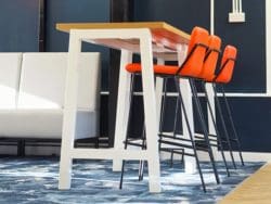 A high poseur table with oak top and white frame and bar stools for school canteen breakout space for sixth form students