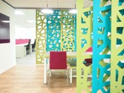 Bright green and blue acoustic sliding screens as part of the breakout area in office