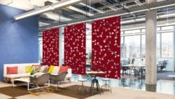 4 red acoustic sliding screens with a floral design to separate a breakout space from a large working office area