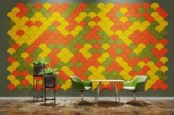 Yellow, green and orange fabric wall tiles in a scallop shape behind an informal breakout area with soft seating