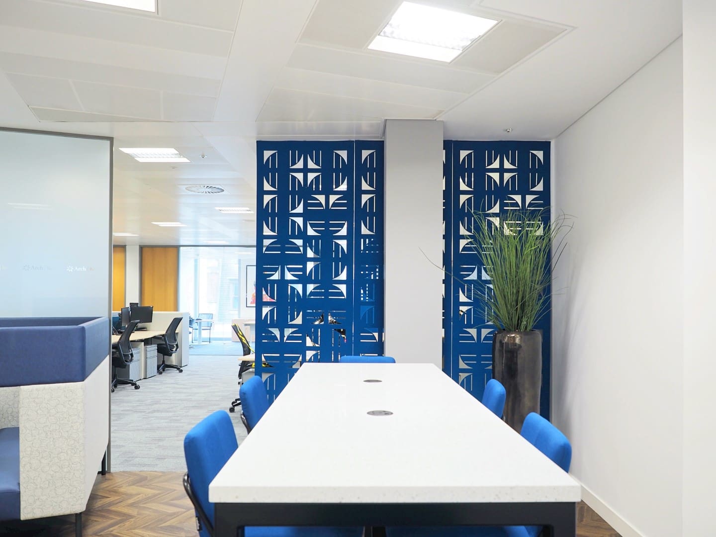 An office poseur table with power and hanging acoustic panels