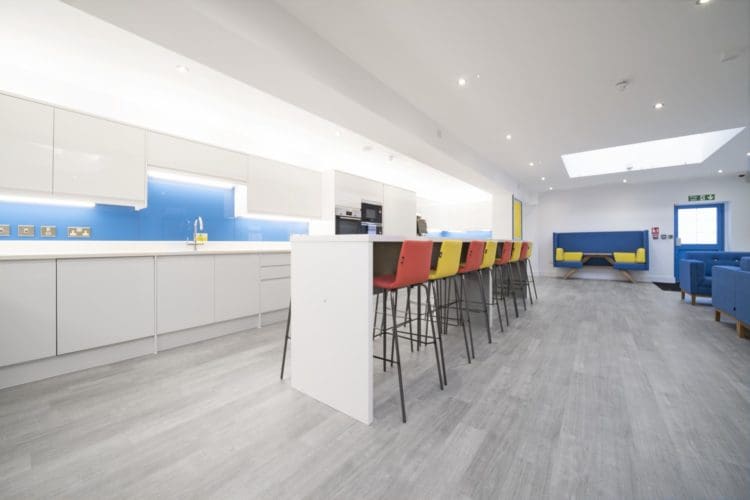 School staffroom kitchen with a poseur table and stools