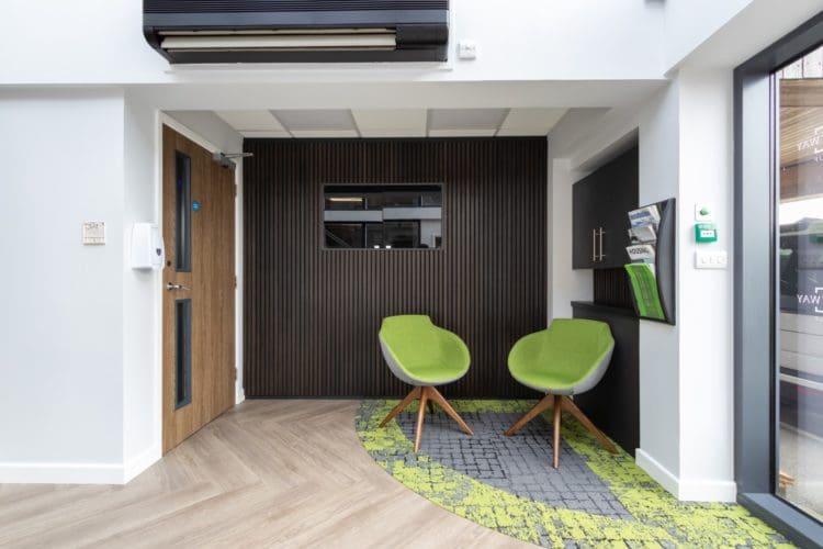 Sustainable office waiting area interior design with a slat wall and tv