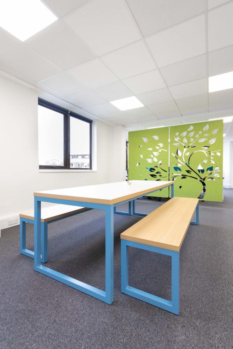 Office breakout area design with a metal framed dining bench and hanging acoustic feature