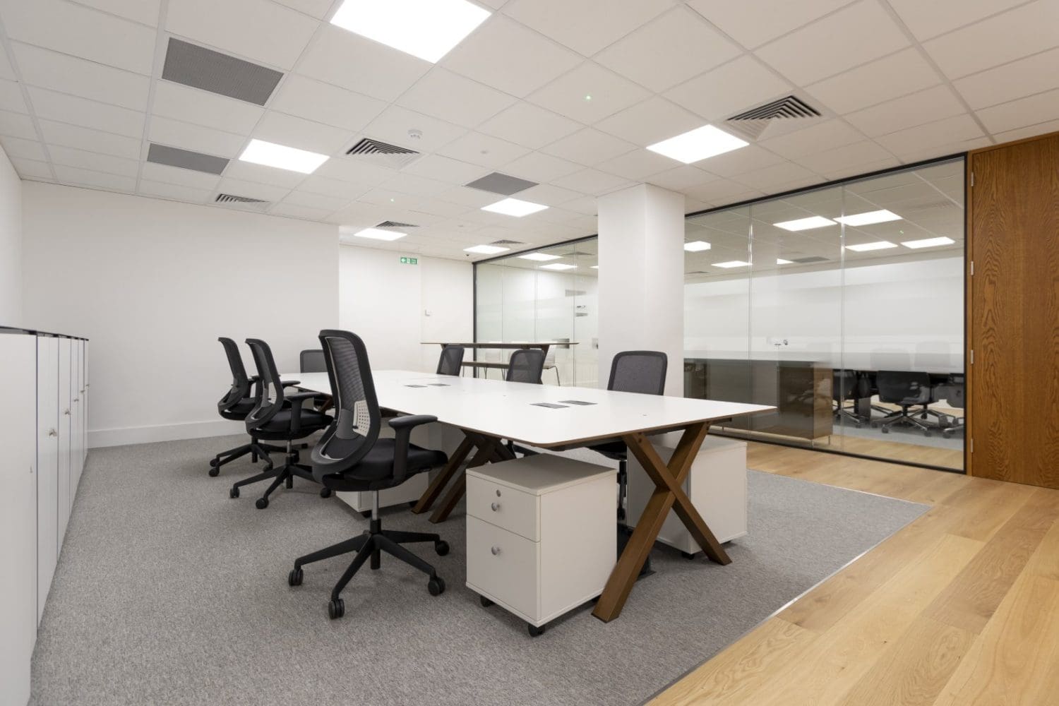 Large glass partition and a shared office desk in the City of London