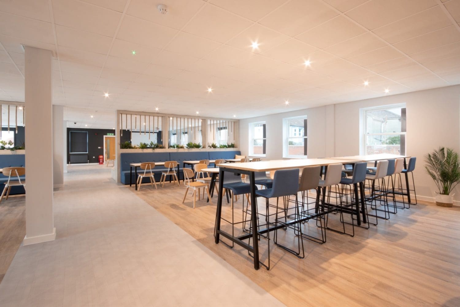 Large office breakout area design with stools and high chairs for dining