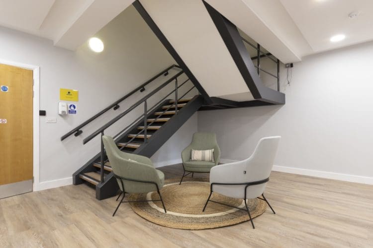 Office lobby area design with soft seating and a re-painted staircase