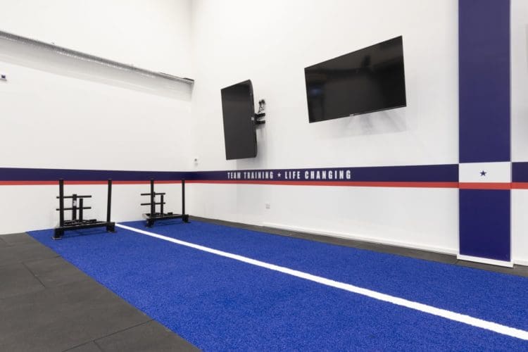 Gym interiors with inspirational quotes and a sled track