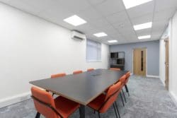 Office boardroom with mottled carpet and a cube storage unit