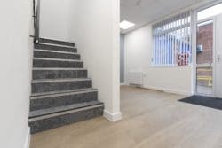 Refurbished office lobby area with vinyl flooring and stairs