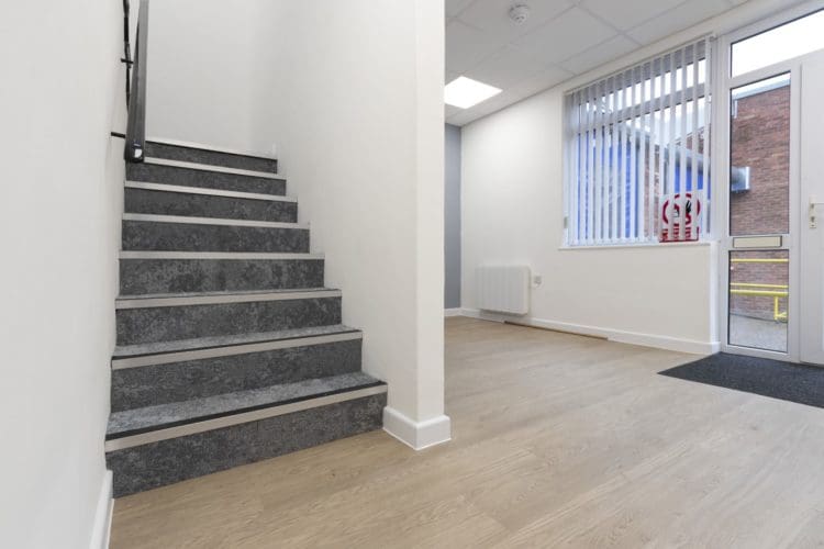 Refurbished office lobby area with vinyl flooring and stairs