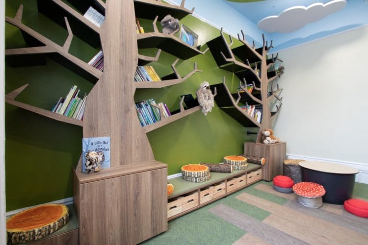 School library forest feature wall with branches for bookshelves