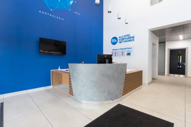 Bespoke office reception desk design with timber slats and concrete