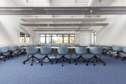 IT classroom interior design project with new school desks and blue swivel chairs.
