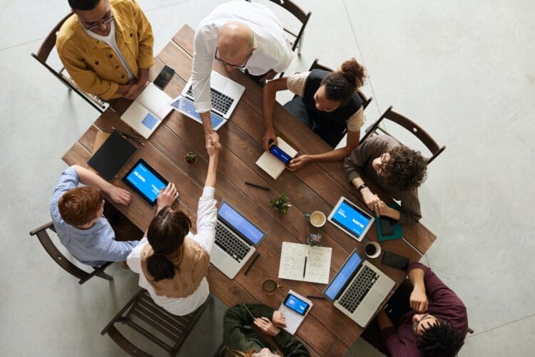 Office team meeting in office breakout area with a collaboration table.