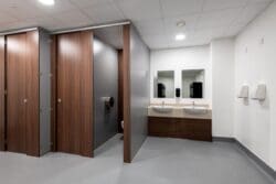 Wood effect toilet cubicles and wash basins in staff washroom fit out for Albion Fine Foods in Dartford, Kent.