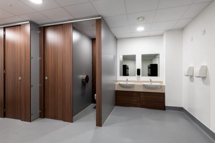 Wood effect toilet cubicles and wash basins in staff washroom fit out for Albion Fine Foods in Dartford, Kent.