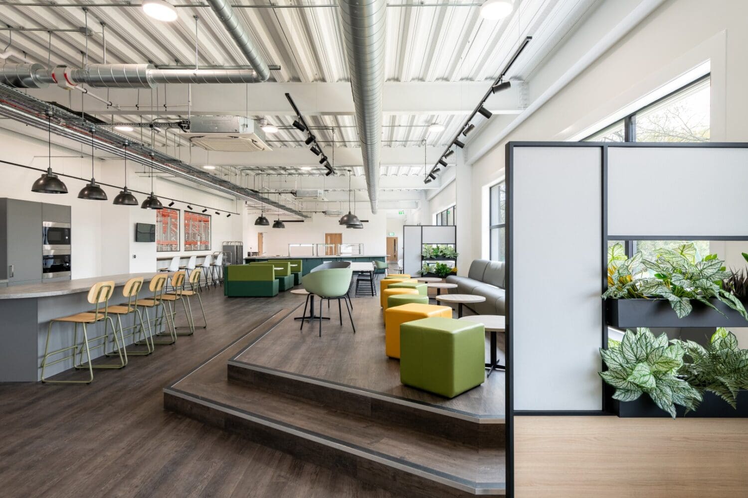 Banquet seating and coffee tables in breakout space for an industrial warehouse fit out project.